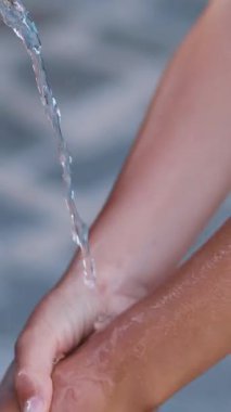 Eski bir Demir Pınar 'dan kristal berrak su akar. Çocuk bir dere altında ellerini yıkar. Kapat.