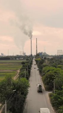 Aero. alan, büyük bir bitki, iki uzun boylu, büyük, Sigara bacaları giden bir yol araçları ile ortada. gri Duman boruları dışarı geliyor. ekoloji, çevre kirliliği.