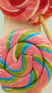 Yakın plan, çok renkli lolipoplar, şekerler, krakerlerin altın parıltılarının arka planı, şenlikli süsler, dekorasyonlar. Çocuk tatili için süslemeler