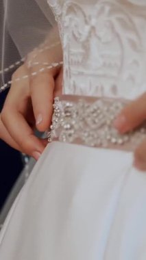 Gelin ücretleri. Gelin, düğün için giyinmiş. Gelinin ellerini, beyaz dantelli bir elbisenin arka planına nazikçe manikürle yakın plan çek. Gelinlik ayrıntıları, kapatın.