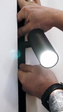 Yol gösteren lamba. Aydınlatma Yakın plan. Adam lamba kuruyor. Aydınlatma armatürlerinin kolay kurulumu. Modern lambalar. Yeni ışıklandırma teknolojisi, enerji tasarrufu.