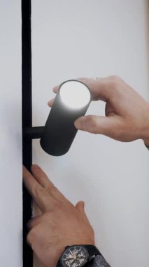 Yol gösteren lamba. Aydınlatma Yakın plan. Adam lamba kuruyor. Aydınlatma armatürlerinin kolay kurulumu. Modern lambalar. Yeni ışıklandırma teknolojisi, enerji tasarrufu.