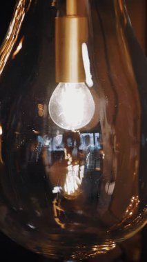 Lambayı açıp kapamak, avize. Yakın plan. Edison filamanlı ampul. Parlayan lamba. Edison filamanlı klasik tip lamba kapanıyor ve açılıyor.