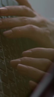 Yakın çekim, laptop ekranında yansıma. Ofiste, beyaz masada dizüstü bilgisayarda klavyeyle yazı yazan bir iş kadınının el resmi..