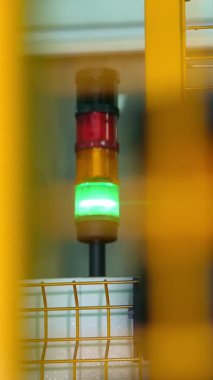 Closeup, fabrikada yeşil ve kırmızı elektrik ampulleri . uyarı işareti, fabrikada çit arkasında ekipman.
