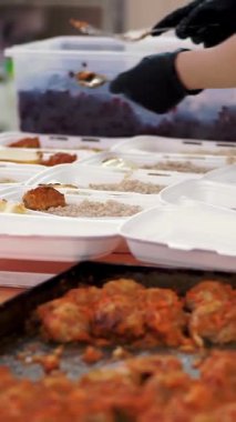 Gönüllüler, fakir ve evsiz insanlara Covid19 'un tecridi sırasında bedava sıcak yemek paketleri hazırlıyorlar. Yemek servisi. Yardım projesi, bağış yardımı,