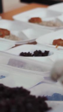 Yakın plan, tek kullanımlık eldivenler. Yemek kutusundan salata koy. Gönüllüler tarafından 19. yılda fakirlere ücretsiz sıcak yemek dağıtılıyor. Yemek servisi.