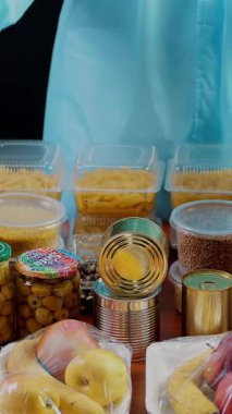 Yakın plan, koruyucu giysili gönüllü, eldiven karton bağış kutusuna bakkal paketi. Coronavirus sırasında paket servis, kapı yemek servisi. İnternetten alışveriş. Hayırseverlik