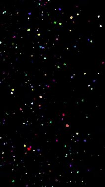 Şenlikli büyülü arka plan. Parıldayan, parıldayan, renkli, kalp şeklindeki parçacıklar siyah arka plana düşüyor. Uçan, titreyen, kalp şeklindeki parçacıklar parıldıyor. .