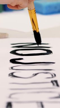 Yakından bakınca, el fırçayla slogan yazıyor, beyaz afişte siyah suluboya boya kullanıyor, afiş asıyor. Amerika 'da ve dünyada eşit haklar için ırkçılığa karşı protestolar.