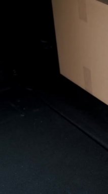 Yakın plan, araba bagajı. Erkek kurye, koruyucu maske, eldivenler, yükleme paketleri, karton kutuları bagaja koymak, kargo teslimat servisi karantina altında, koronavirüs salgını.