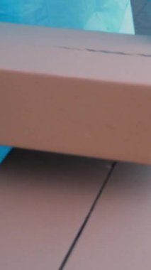 Yakın plan, Coronavirus salgını sırasında hastaneye tıbbi ekipman ya da uyuşturucu taşıyan paket teslimatı. Kurye, koruyucu kıyafetli, hemşireye karton kutular veriyor. Kargo teslimat servisi karantina sırasında.