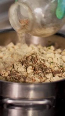 Yemek pişirmek. Yakın plan. Şef, koruyucu eldivenlerle çorbaya baharat koyar ve tencereyle büyük kaşıkla karıştırır. Sağlıklı yemek. Güvenlik kavramı. Matarayı yeniden açıyorum. Gönüllülük ve yardım