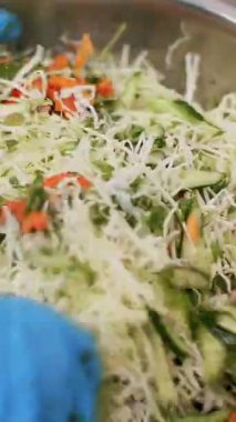 Yemek pişirmek. Yakın plan. Şef koruyucu eldivenlerle büyük bir kasede salata hazırlıyor. Sağlıklı yemek. Güvenlik kavramı. Matarayı yeniden açıyorum. Gönüllülük ve yardım