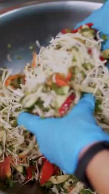 Yemek pişirmek. Yakın plan. Şef koruyucu eldivenlerle büyük bir kasede salata hazırlıyor. Sağlıklı yemek. Güvenlik kavramı. Matarayı yeniden açıyorum. Gönüllülük ve yardım