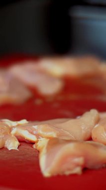 Yemek pişirmek. Yakın plan. Kesme tahtasının üzerinde küçük çiğ tavuk eti parçaları var. Sağlıklı yemek. Gönüllü olmak ve yardım. Yeniden açılıyor. güvenlik kavramı.