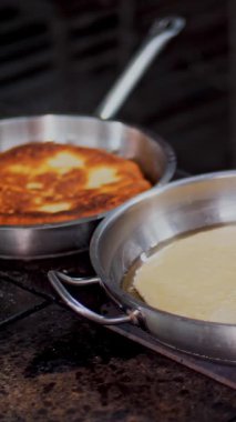 Yemek pişirmek. Yakın plan. Şef, koruyucu eldivenlerle, büyük bir tortilla, pide ya da tavada krep kızartır. Sağlıklı yemek. Gönüllü olmak ve yardım. Yeniden açılıyor. güvenlik kavramı.