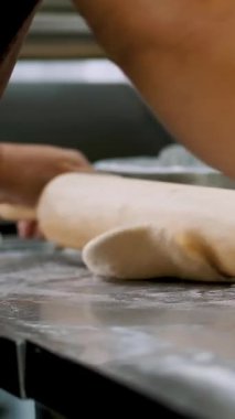 Yemek pişirmek. Fırın. Yakın plan. Kadın elleri mutfak masasına un serpiştirilmiş hamuru yuvarlıyor. Sağlıklı yemek. Yeniden açılıyor. Gönüllülük ve yardım