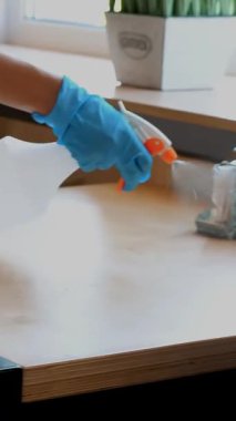 Yakın plan. Garson, koruyucu eldiven giyiyor, ziyaretçiler için masaları dezenfekte ediyor. Koronavirüsü korumak için antiseptik sprey kullanıyor. Kafeteryayı ya da restoranı yeniden açmak. güvenlik kavramı.