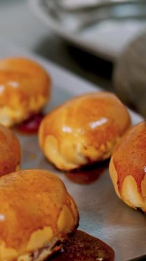 Yemek pişirmek. Fırın. Yakın plan. Fırıncı koruyucu eldivenlerle fırından yeni çıkmış hamur işlerini kaldırıyor. Sağlıklı yemek. Covid-19 'dan sonra tekrar açılıyor. Güvenlik kavramı. Gönüllülük ve yardım.