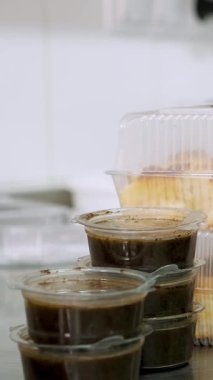 Yemek pişirmek. Yakın plan, gönüllü, mutfak çalışanı, koruyucu eldivenler giymiş, fakirlere dağıtılmak üzere beslenme çantalarında dilimlenmiş ekmek paketliyor. Yemek servisi. Yardım projesi, bağış yardımı,