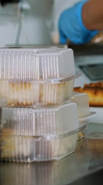 Yemek pişirmek. Yakın plan, gönüllü, mutfak çalışanı, koruyucu eldivenler giymiş, fakirlere dağıtılmak üzere beslenme çantalarında dilimlenmiş ekmek paketliyor. Yemek servisi. Yardım projesi, bağış yardımı,