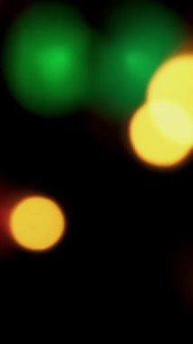 Soyut sahte arkaplan hareket halinde. Parlak, bulanık altın parçacıklar, ışıklar. Koyu arkaplandaki çelenklerden parlak bir bokeh. Yeni yıl ya da Noel arkaplanı.