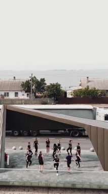 CHERKASSY, UKRAINE, 24 EYLÜL 2020: açık havada grup fitness eğitimi. Genç sporcular spor için barajdaki gözlem güvertesine nehrin panoramik manzarasıyla gidiyorlar. Spor Kulübü. Havadan çekim. Refah yaşam tarzı konsepti