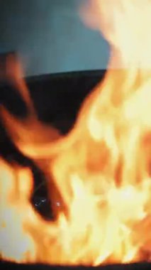 Aşçılık. Hamburger pişirmek. Manzarayı kapat. Lokanta mutfağında barbekü ızgarası var. Alevler ve duman yavaş çekimde. Fast food, abur cubur