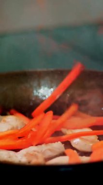 Yemek pişirmek. Yakın plan. Sebzeli et parçaları tavada kızartılır. Aşçılık