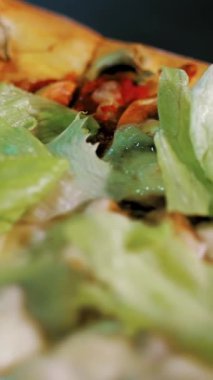 Aşçılık. Pizza yapmak. Yakın plan. Lezzetli, sulu, taze hazırlanmış, üzerinde marul yaprakları ve bitkiler olan sıcak pizza. İtalyan pizzası pişirme süreci .