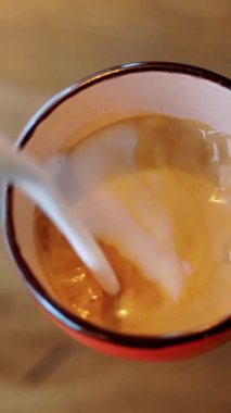 Profesyonel kahve demleme. Yakın plan. Kahve fincanı latte sanatı. Kahveci sütlü sütlü kahve yapıyor, kahve köpüğüne süt kalıbı çiziyor..