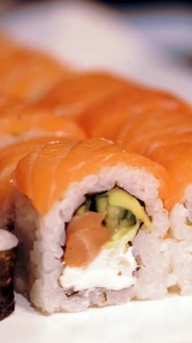 Geleneksel Japon yemekleri. Yakın plan. Yeni pişmiş, çeşitli suşi dürümleri bir teslimat kutusunda suşi büfesi..