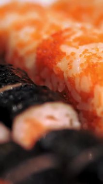 Geleneksel Japon yemekleri. Yakın plan. Yeni pişmiş, çeşitli suşi dürümleri bir teslimat kutusunda suşi büfesi..