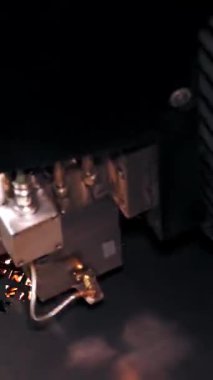 Metal levha için lazer kesme makinesi. Yakın plan. Üst Manzara. CNC fiber lazerli modern makine metal levha üzerindeki desenleri kesiyor. Kesme işlemi sırasında lazer ışınından parlak kıvılcımlar uçuşuyor