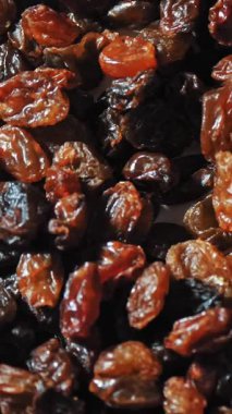 Kuru üzüm. Yakın plan. Rotasyon yemeği. Üzüm arka planı yavaş döner, üst görünüm. Sağlıklı beslenme için kuru meyve, hafif ve koyu kuru üzüm. Yemek geçmişi. Gastronomi konsepti, organik gıda..