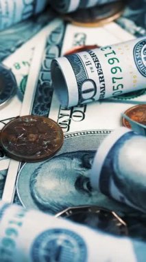 Para için. Dolar banknotları ve bozuk paralar. Yakın plan. Döndürme. Bir sürü yüz dolarlık banknot ve farklı paralar döner. Makro manzara. Para arkaplanı döndürülüyor.