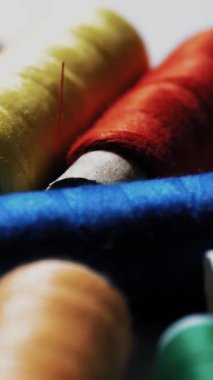 Dikiş aletleri. Dikiş iplikleri. Yakın plan. Döndürme. Farklı renkte iplik makaraları. Hobiler, el sanatları. El yapımı.