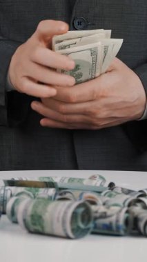 İş adamı, para, para. Yakın plan. İş adamı, resmi takım elbiseli, elinde tutuyor, dolarları sayıyor, sonra da cebine koyuyor. Rüşvet, yolsuzluk konsepti. Finans ve yatırım, başarı kavramı.