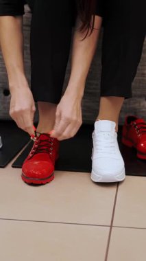 Ayakkabılar. Ayakkabıları dene. Yakın plan. Spor ayakkabılar. Ayakkabı dükkanı. Beyaz koşu ayakkabıları. Kadın ayakkabı mağazasında yeni beyaz ayakkabılar deniyor.