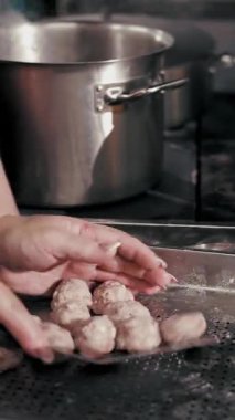 Yarı bitmiş et ürünleri. Yemek pişirmek. Yakın plan. Şef, yarı bitmiş et ürünlerini, donmuş köfteleri kaynar suya koyar. Ticari bir mutfakta yemek pişirmek..