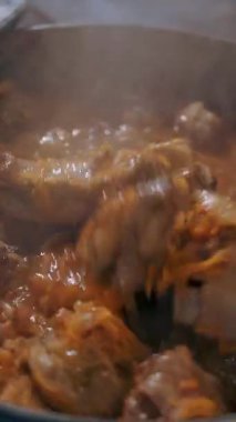 Yemek pişirmek. Güveç. Açık büfe restoran mutfağı. Yakın plan. Yemek kaynıyor, tencerede kaynıyor. Ticari bir mutfakta yemek hazırlamak ve pişirmek.