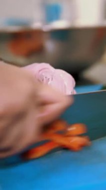 Yemek pişirmek. Şef sebze keser. Açık büfe restoran mutfağı. Yakın plan. Şef, plastik tahta üzerinde keskin, büyük bir mutfak bıçağıyla taze çan biberini küçük parçalara ayırıyor..