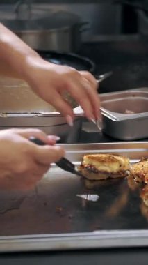 Patates kızartması. Patates köftesi. Yemek pişirmek. Patates keki, zuela. Açık büfe restoran mutfağı. Yakın plan. Aşçı, kızarmış patatesli kekleri metal tepsiye koyar..