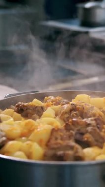 Yemek pişirmek. Güveç. Açık büfe restoran mutfağı. Yakın plan. Yemek kaynıyor, tencerede kaynıyor. Ticari bir mutfakta yemek hazırlamak ve pişirmek.