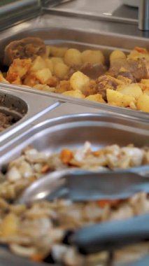 Açık büfe restoranı. Kendi kendine hizmet veren kafeterya. Yakın plan. Yeni pişmiş sıcak yemeklerle sergilenen bir vitrin. sağlıklı gıda.