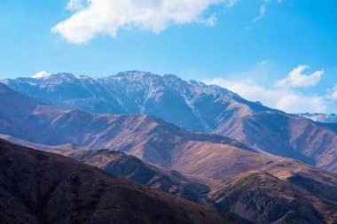 Bulutlu gökyüzü ile inanılmaz bir dağ manzarası. Güzel kırsal kesimin manzarası. Dağlarda harika bir sonbahar. Kuru çayır ve yuvarlanan tepeler. Doğal dış seyahat geçmişi. Güzellik dünyası.