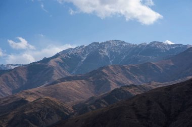 Bulutlu gökyüzü ile inanılmaz bir dağ manzarası. Güzel kırsal kesimin manzarası. Dağlarda harika bir sonbahar. Kuru çayır ve yuvarlanan tepeler. Doğal dış seyahat geçmişi. Güzellik dünyası.