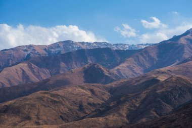Bulutlu gökyüzü ile inanılmaz bir dağ manzarası. Güzel kırsal kesimin manzarası. Dağlarda harika bir sonbahar. Kuru çayır ve yuvarlanan tepeler. Doğal dış seyahat geçmişi. Güzellik dünyası.