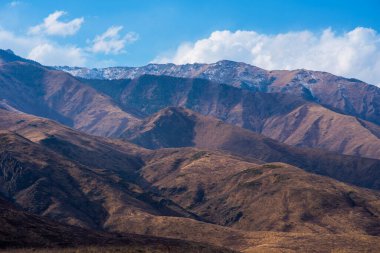 Bulutlu gökyüzü ile inanılmaz bir dağ manzarası. Güzel kırsal kesimin manzarası. Dağlarda harika bir sonbahar. Kuru çayır ve yuvarlanan tepeler. Doğal dış seyahat geçmişi. Güzellik dünyası.